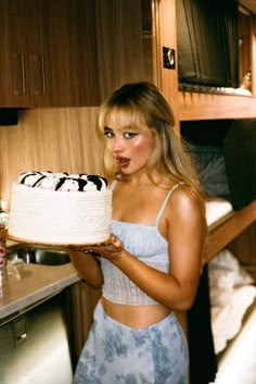 a woman holding a cake in front of her face