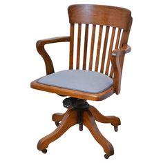 a wooden desk chair with a blue cushion on it's seat and backrest