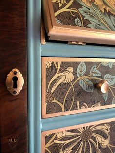 the drawers are painted with flowers and leaves on them, as well as a door handle