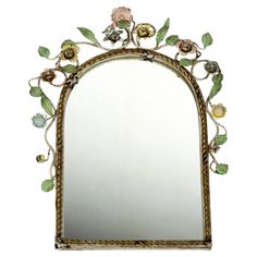 an ornate mirror with flowers and leaves on it