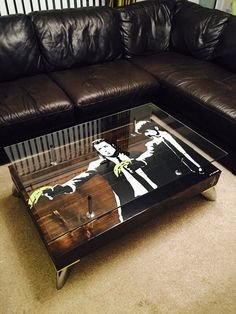 a glass coffee table sitting on top of a carpeted floor next to a couch