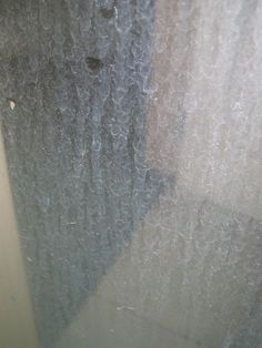 the window is covered with frost and water drops from it's raindrops