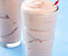 two glasses filled with ice cream on top of a blue table