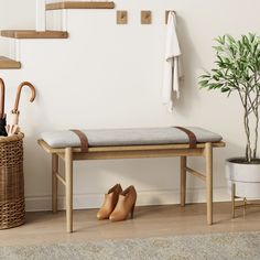 a pair of shoes sitting on top of a wooden bench next to a potted plant