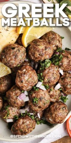 greek meatballs on a plate with lemon wedges