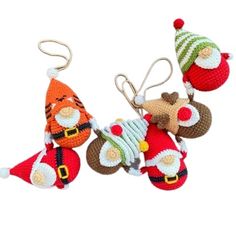 crocheted christmas ornaments with santa claus and other decorations hanging from strings on white background