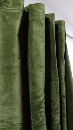 green velvet curtains are lined up in a row and ready to be hung on the wall