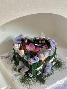 a heart shaped cake decorated with purple flowers