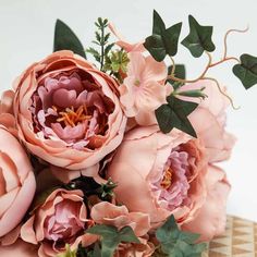 a bouquet of pink flowers sitting on top of a checkered table cloth with green leaves