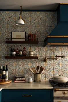 a kitchen with blue cabinets and shelves filled with cooking utensils, wine bottles and other items