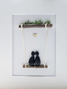 two black shoes are on a swing with a heart hanging from the wall behind them