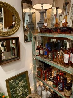 shelves with bottles and jars on them in a room filled with mirrors, lamps and other items