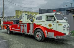 a red and white fire truck parked in front of a building