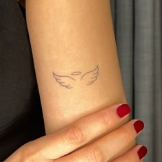 a woman's arm with a small tattoo on it