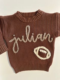 a brown sweater with the word julia written on it's chest and an o - ring at the bottom