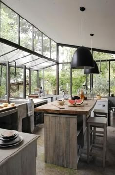 an open kitchen with lots of counter space and large windows on the wall above it