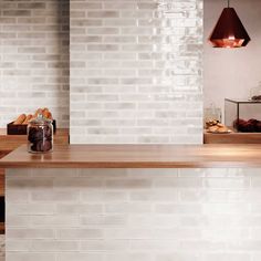 a kitchen with white brick walls and wooden counter tops