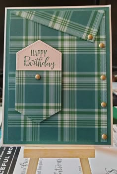 a green plaid card with a happy birthday tag in the pocket on top of it