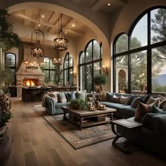 a living room filled with lots of furniture and large windows next to a fire place