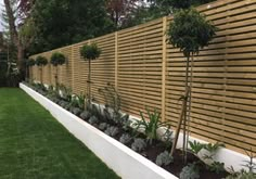 a long wooden fence in the middle of a yard