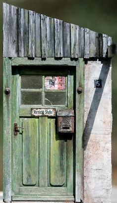 an old wooden door with a sign on it