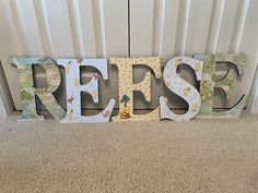 the word reese is made out of wood and letters are painted in white, green, yellow and blue