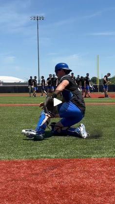 a baseball player kneeling on top of a field