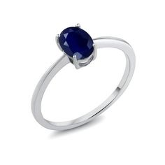 a white gold ring with an oval blue sapphire stone on the center, and a diamond set in the middle