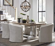 a dining room table with four chairs and a chandelier hanging from the ceiling