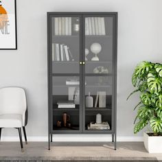 a black book case sitting next to a white chair in a room with a potted plant