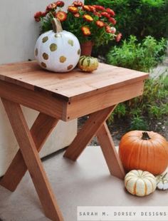 a small wooden table with two pumpkins on it