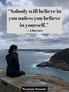 a woman sitting on top of a stone wall next to the ocean with a quote above her that reads nobody will believe in you unless you