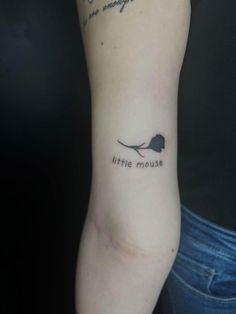 a woman with a tattoo on her arm that says little mouse