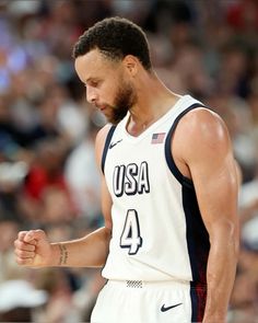 a basketball player holding his fist up in front of an audience