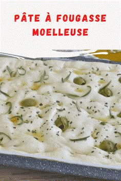 a casserole dish with white sauce and green olives