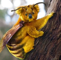 a yellow and brown stuffed animal sitting on top of a tree