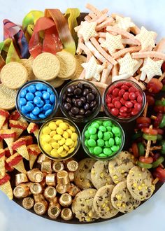 a platter filled with lots of different types of candy and crackers on top of it