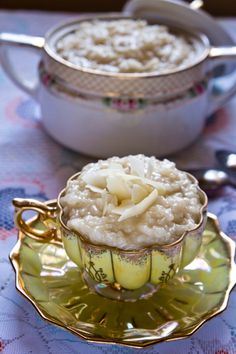 a bowl of oatmeal on a saucer with spoons next to it