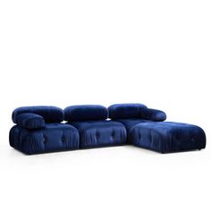 a large blue sectional sofa with pillows on it's back and arms, in front of a white background