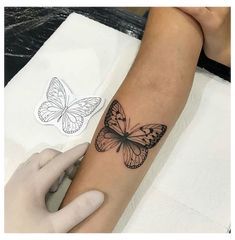 a woman's arm with a butterfly tattoo on the left side of her arm