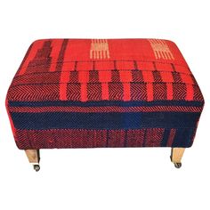 a red and blue foot stool with wheels on the bottom, sitting in front of a white background