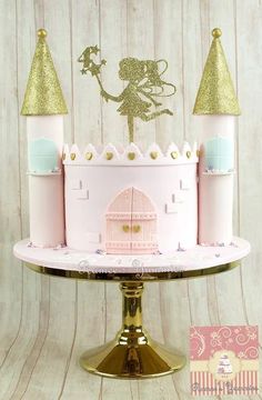 a pink and gold princess castle cake sitting on top of a metal stand with glitter decorations