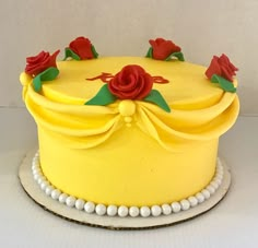 a yellow cake with red roses on top