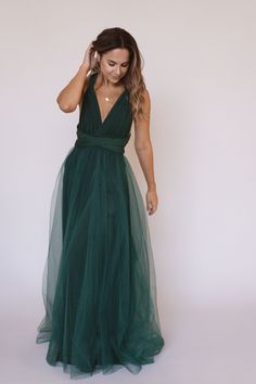 a woman in a green dress is posing for the camera with her hand on her head