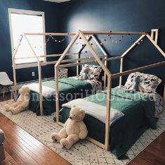 two teddy bears sitting on the floor in a room with blue walls and wooden floors