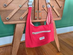 a red purse hanging from a wooden chair