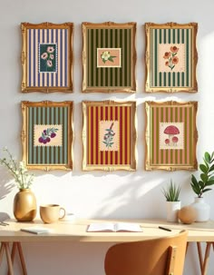 four framed pictures hang on the wall above a table with a vase and potted plant