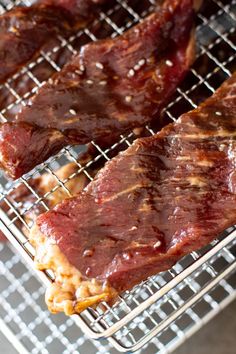 two pieces of meat sitting on top of a metal rack