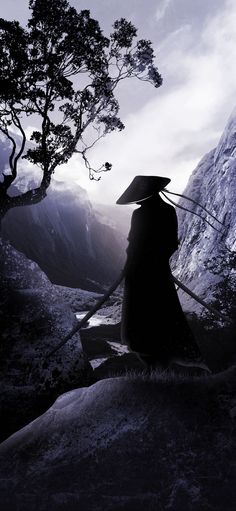 a person sitting on top of a rock with an umbrella over their head and mountains in the background