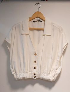 a white blouse hanging on a hanger